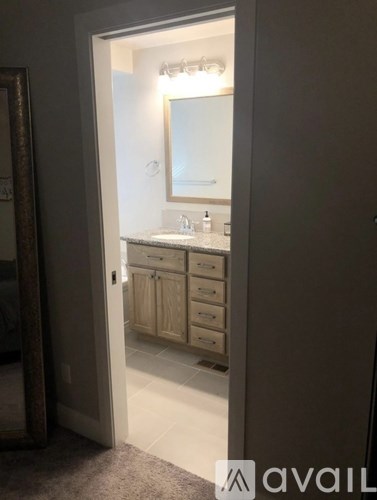 A bathroom with a sink, mirror, and cabinets.