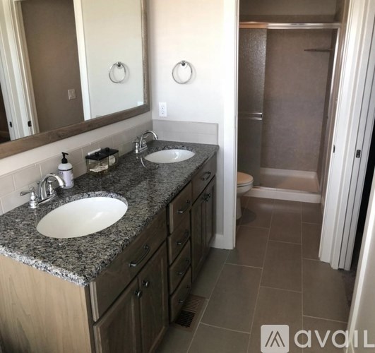 A bathroom with granite countertops and two sinks.
