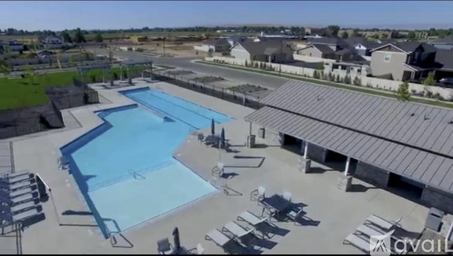 An outdoor swimming pool surrounded by a parking lot.