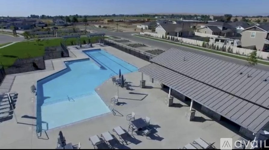 A large outdoor swimming pool surrounded by a metal roofed pavilion.