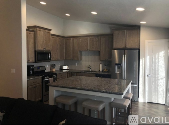 A kitchen with a granite countertop and stainless steel appliances.