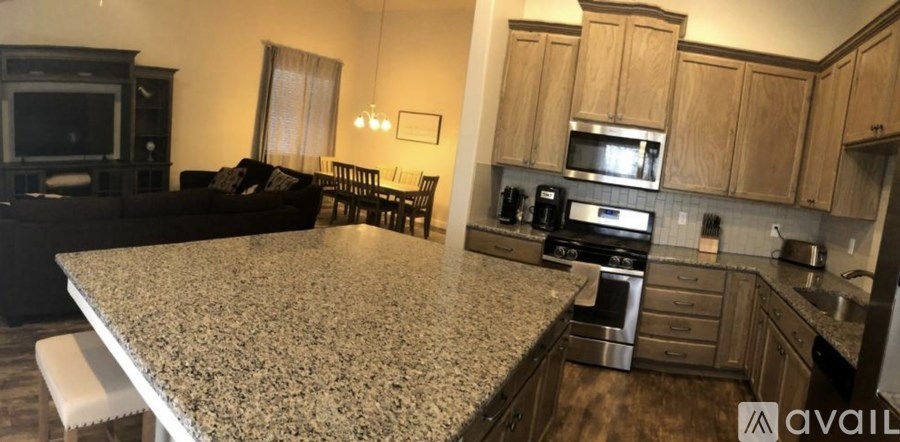 A kitchen with granite countertops and wooden cabinets.