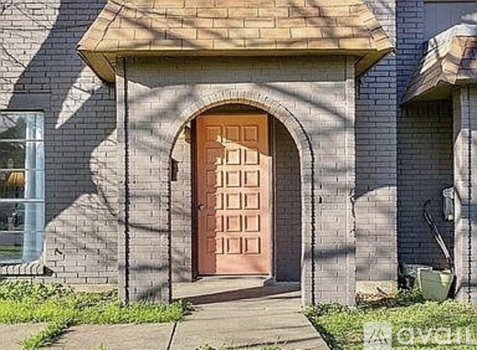 A house with a brown door and a stone wall.