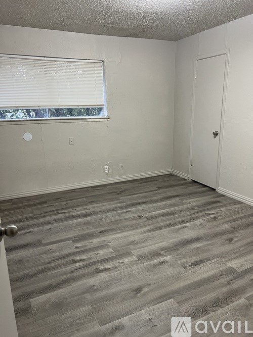 A room with a wooden floor and a white door.