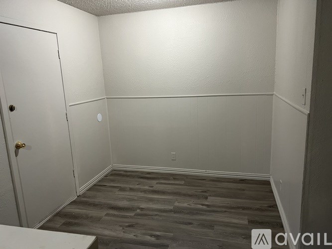 A room with a wooden floor and white walls.
