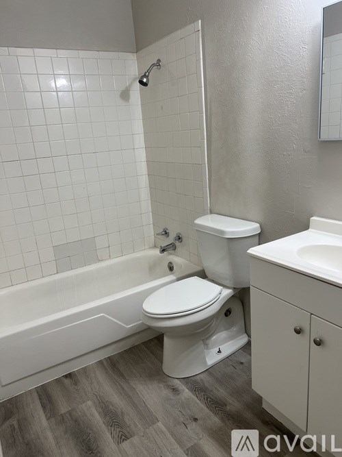 A white toilet sits next to a bathtub in a bathroom.