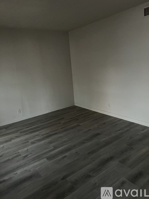 A room with wooden flooring and white walls.