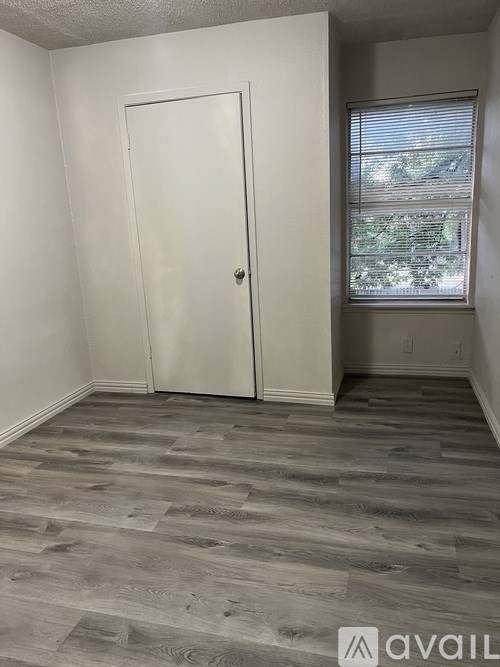 A room with a white door and a window with blinds.