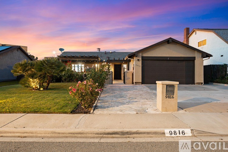 A house with the number 9816 on the mailbox and the sidewalk in front of it.