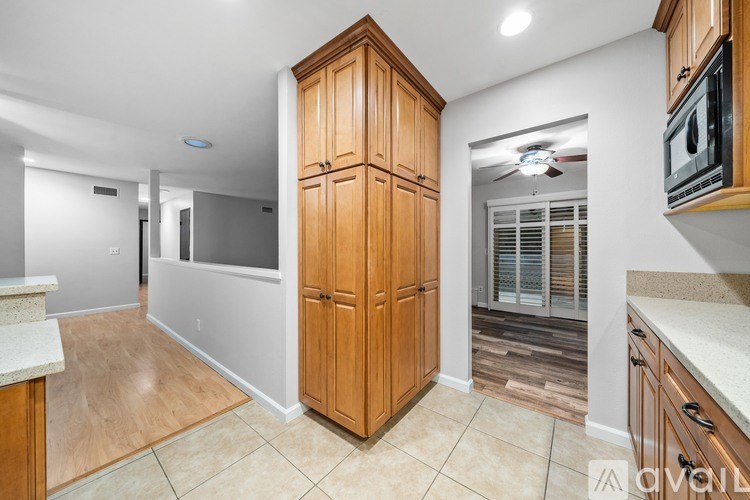 A kitchen with wooden cabinets and a tiled floor.