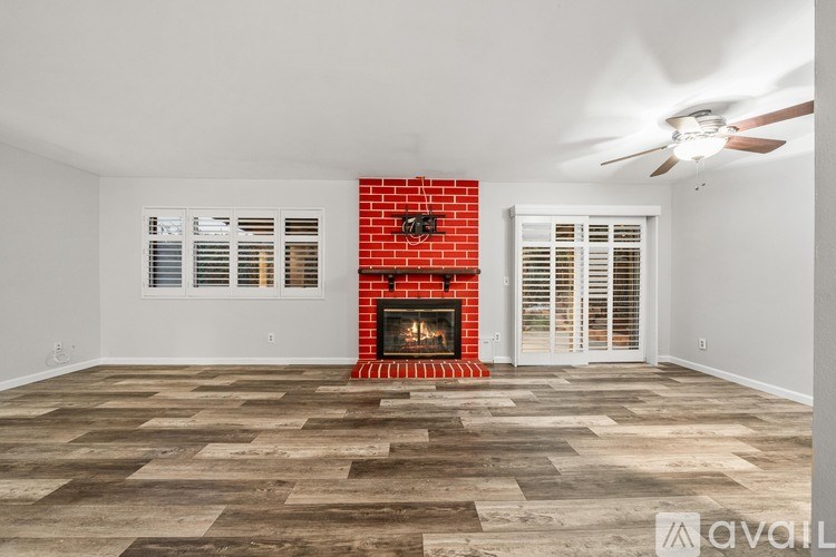 A room with a fireplace and a ceiling fan.