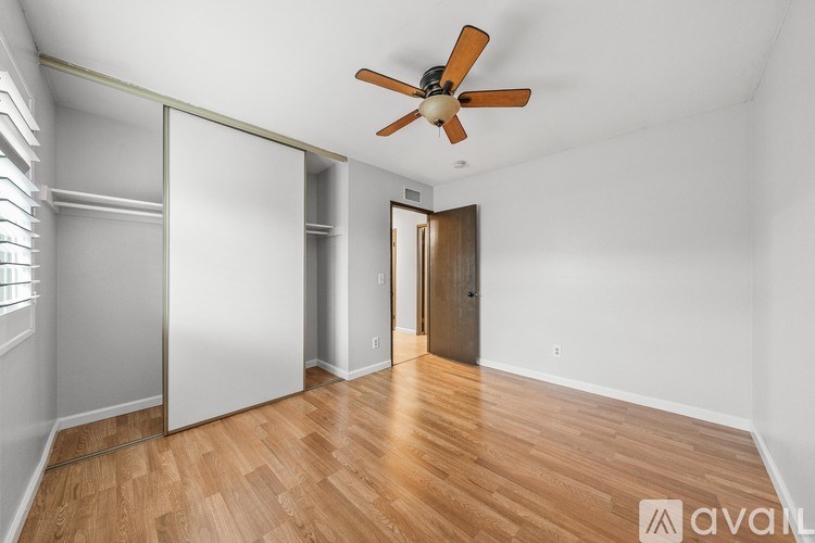 A room with wooden floors and a ceiling fan.