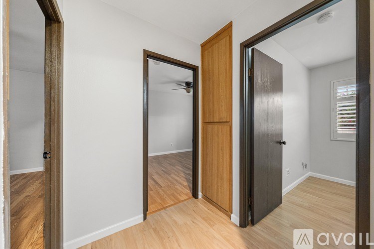 A room with a wooden floor and a black door.