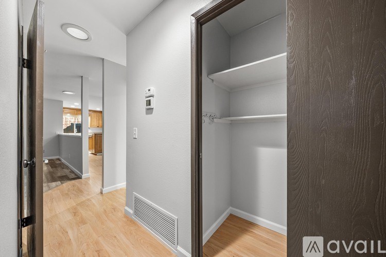 A walk-in closet with a wooden door and shelves.