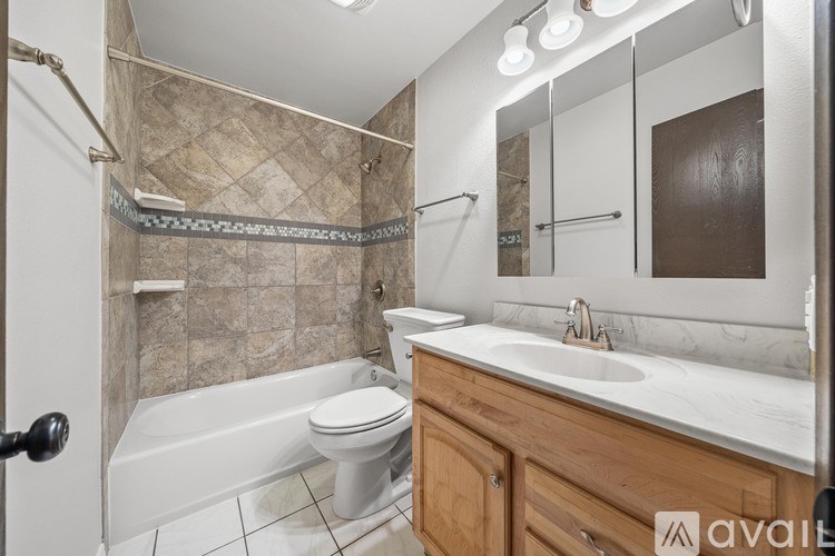 A bathroom with a toilet, sink, and shower.