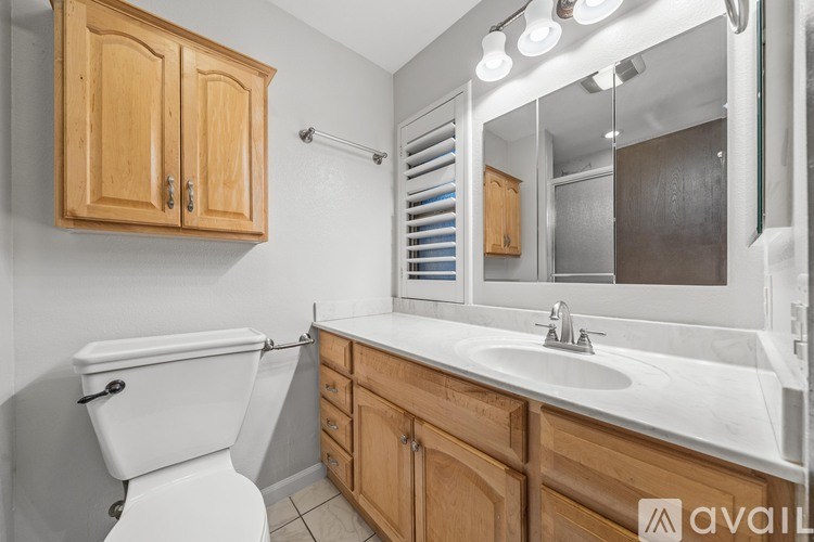 A bathroom with wooden cabinets and a white toilet.
