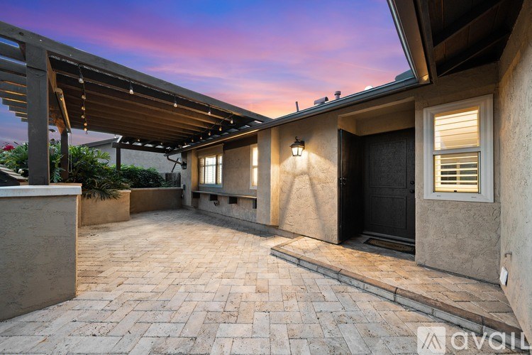 A patio area with a black door and a black gate.