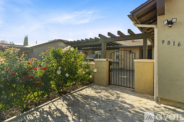 A house numbered 9816 with a gate and a garden in front.