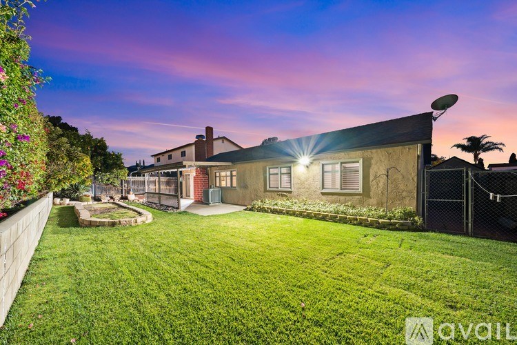 A house with a well-maintained lawn and a fence is shown in the image.