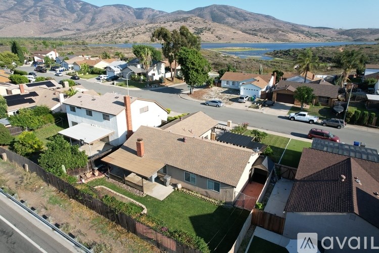 A bird's eye view of a residential area with houses and a lake in the background.