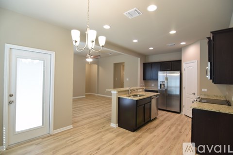 A kitchen with wooden floors and a center island with a sink.