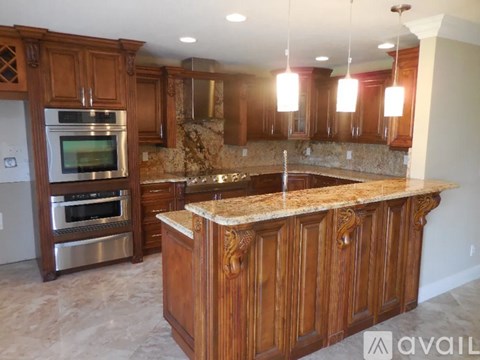 A kitchen with wooden cabinets and a granite countertop.