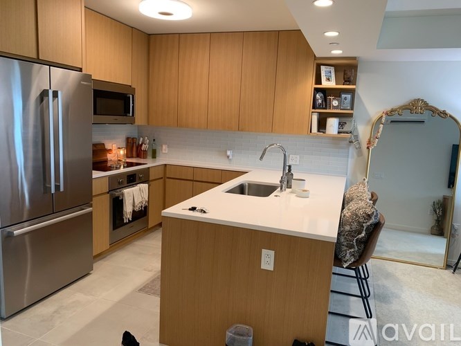 A kitchen with wooden cabinets and a stainless steel refrigerator.