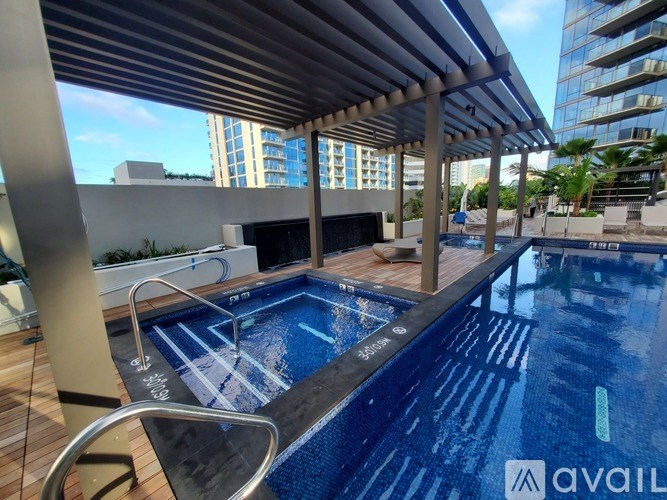 A modern pool area with a wooden deck and a metal railing.