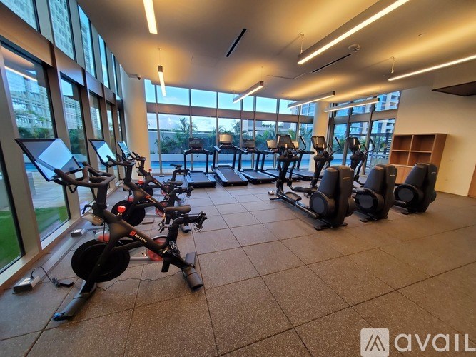 A gym with exercise equipment and large windows.