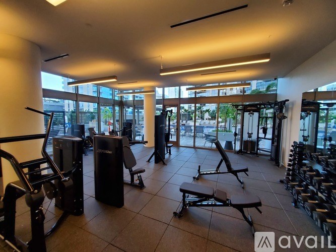A gym with a variety of equipment including treadmills, weights, and benches.