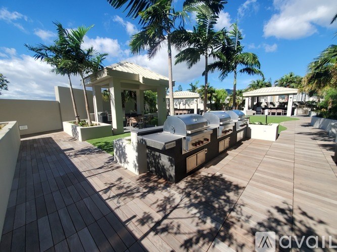 A wooden deck with a white building and palm trees in the background.