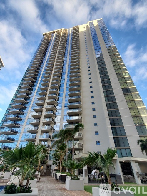 A tall building with balconies and a pool in front.