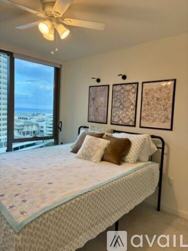 A bedroom with a large bed and a ceiling fan.