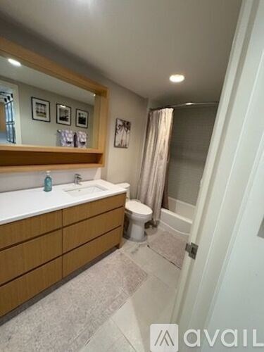 A bathroom with a sink, toilet, and a mirror.
