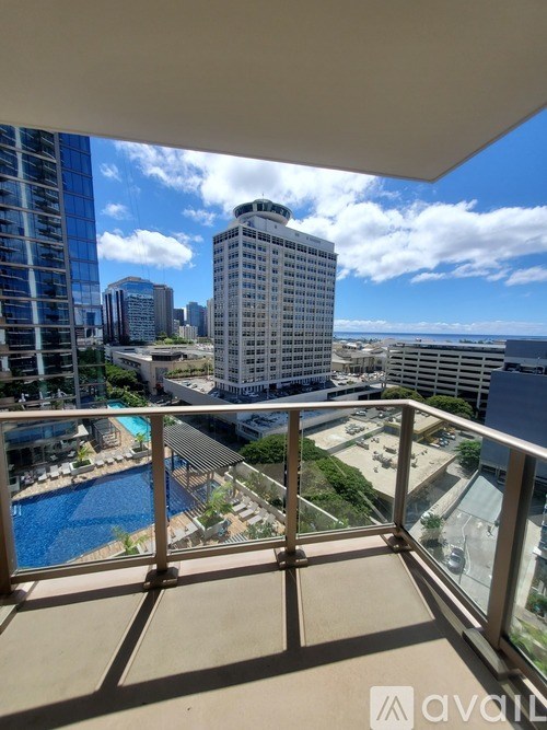 A balcony overlooks a pool and a cityscape.
