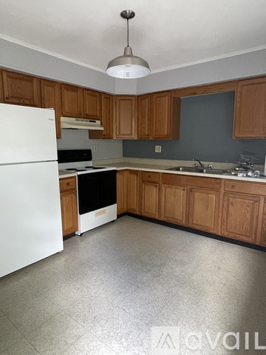 A kitchen with wooden cabinets and a white refrigerator.