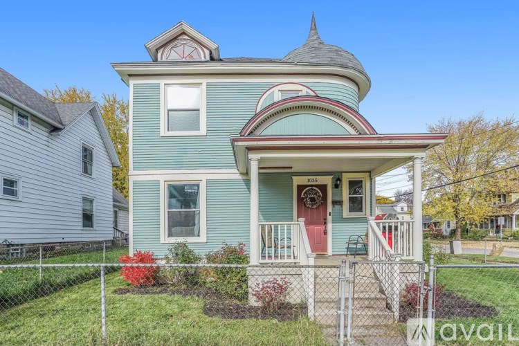 A house with a blue front and a red door.