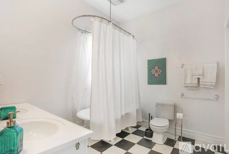 A white bathroom with a black and white checkered floor.