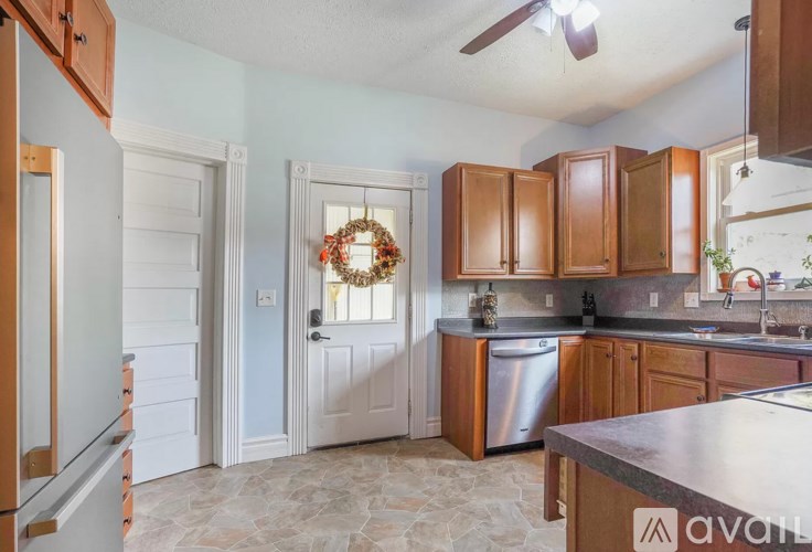 A kitchen with wooden cabinets and a stainless steel dishwasher.