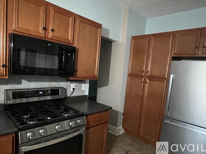 A kitchen with wooden cabinets and a black stove top.