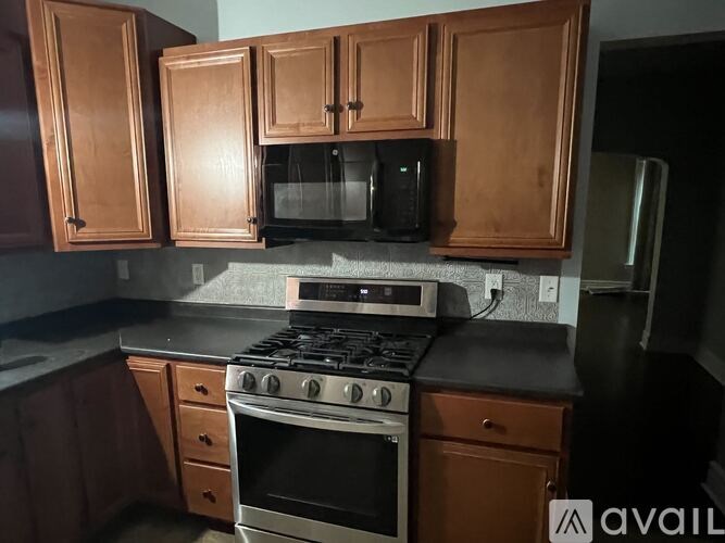 A kitchen with wooden cabinets and a black stove top.