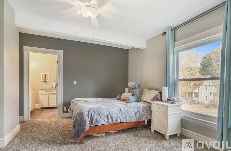 A bedroom with a bed, dresser, and window.