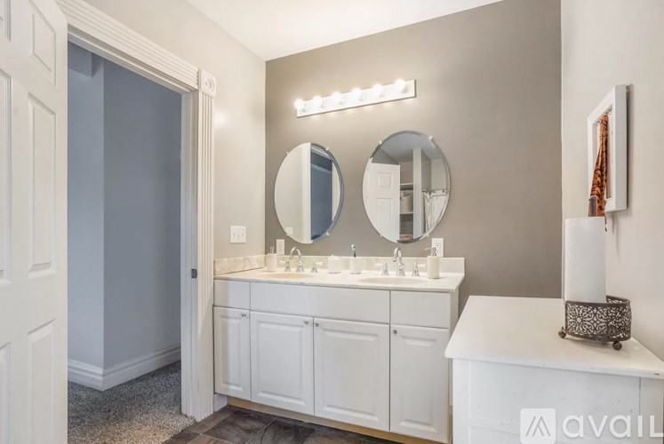 A bathroom with a white vanity and a mirror above it.