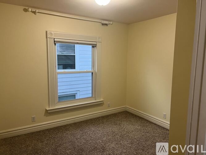 A room with a window and carpeted floor.