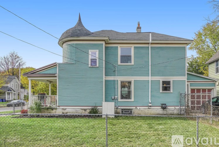 A blue house with a white fence in front.