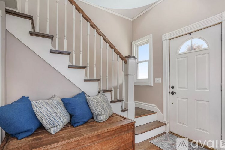 A staircase with a bench at the bottom and a door on the right.