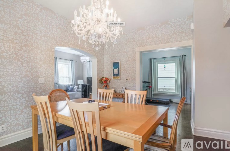 A dining room with a wooden table and chairs.