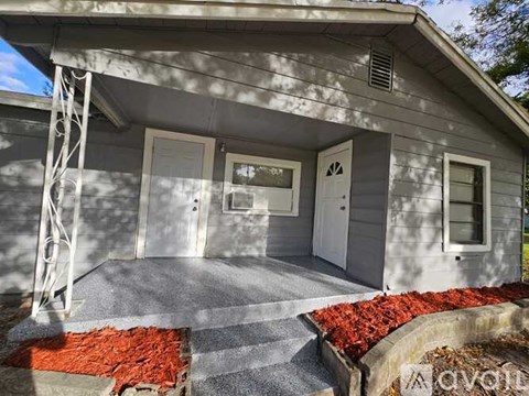 A grey house with a white door and windows.