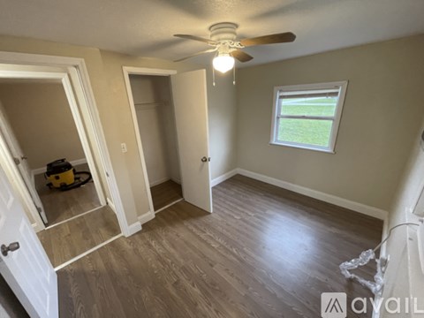 A room with a ceiling fan and a window.