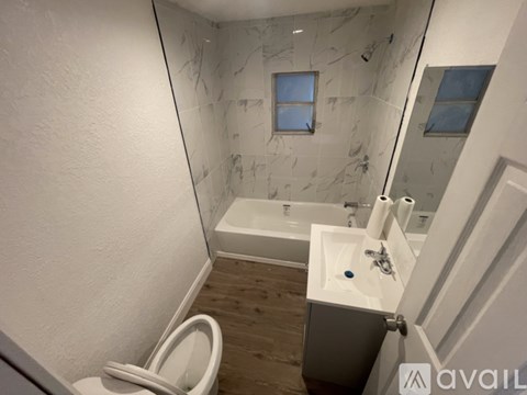 A bathroom with a marble wall and a white toilet.